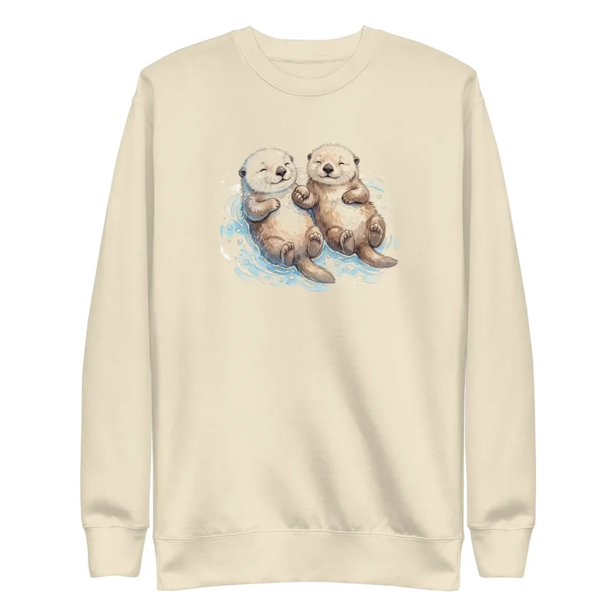 Cream sweater with two otters floating on their backs holding hands